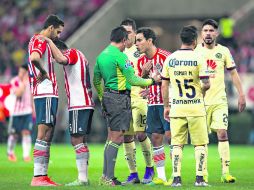 Polémico. El árbitro del encuentro, Fernando Guerrero (centro), dialoga con el capitán de Chivas, Omar Bravo. MEXSPORT / J. Ramírez