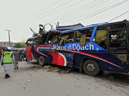 Miembros de las Fuerzas de Seguridad inspeccionan el autobús afectado, en Peshawar. EFE / B. Arbab