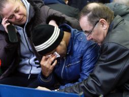 Familiares de las víctimas del avionazo lloran mientras esperan noticias sobre los restos de sus seres queridos. AFP /