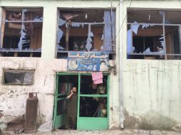 Un hombre habla por teléfono desde la entrada de su tienda, dañada por la explosión. EFE / J. Jalali