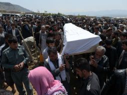 Varias personas participan en el funeral de una de las víctimas mortales del ataque de ayer. AFP / S. Marai