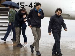 Sastre (d), López (c) y Pampliega (i, abrazando a un familiar), a su llegada esta mañana a la Base Aérea de Torrejón de Ardoz. EFE / D. Crespo