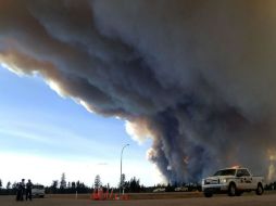 Pese a la evacuación, permanecen en la zona incendiada unos 200 bomberos que luchan contra las llamas. AFP /