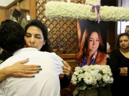 Familiares de una de las víctimas se abrazan durante el servicio fúnebre hecho en su memoria. AFP / STR