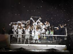 El entrenador, los jugadores y el equipo técnico desfilaron sobre una pasarela luminosa, entre los vítores de la multitud del Bernabéu. EFE / F. Villar