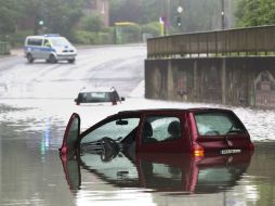 Imagen que muestra un coche parcialmente sumergido en un paso inferior en Oberhausen. EFE / M. Kusch