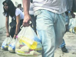 Tres kilos de arroz, uno de leche, otro de azúcar, un paquete de frijoles negros y un litro de aceite es la ayuda. AFP /