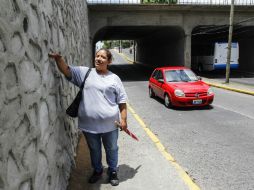 La señora Olga Michel señala el nivel que alcanza el agua al inundar el paso a desnivel de Washington y Héroes Ferrocarrileros. EL INFORMADOR / A. García