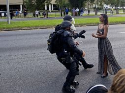 La mujer, con vestido largo salió de entre la multitud y se plantó frente a la policía durante una protesta en Baton Rouge. AP / M. Becherer