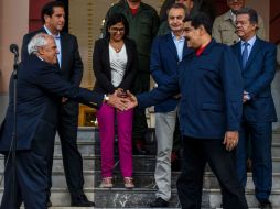 El presidente Nicolás Maduro (der) y Ernesto Samper (izq) se dan la mano luego de la inclusión de El Vaticano. AFP / J. Barreto