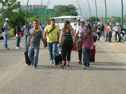 Unos viajeros se trasladan a pie hacia el aeropuerto de Chiapas. EFE / R. Arauxo