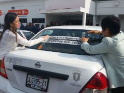 Funcionarios de la Contraloría Municipal y de la Coordinación de Administración pegan calcas para promocionar la campaña. TWITTER / @ZapopanGob