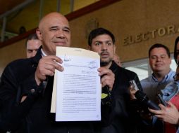 El dirigente opositor Juan Carlos Caldera mostró el certificado luego de retirarlo de las oficinas del CNE. AFP / F. Parra