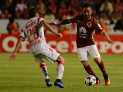 Arturo Paganoni (d) de América y Osmar Meneses (i) de Tiburones Rojos de Veracruz, disputan el balón. EFE / P. Morales
