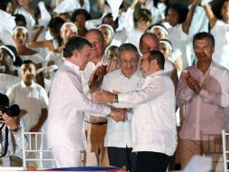 Santos y 'Timochenko' firmaron el acuerdo de paz entre aplausos y gritos de los asistentes a la ceremonia en Cartagena. AFP / L. Acosta