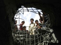 Un grupo de niños observa un hoyo que dejó una agresión saudí. AP / H. Mohammed