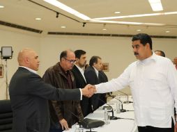 El secretario de la alianza opositora, Jesús Torrealba, y Nicolás Maduro tras la primera reunión. EFE / Prensa Miraflores