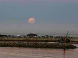 La Luna se leventa sobre el horizonte en la bahía de Lambert, en Sudáfrica. AP /  Van Zuydam