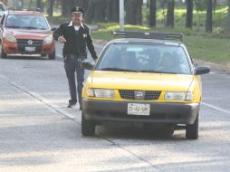 Un agente de Movilidad detiene a un taxi por dar servicio 'colectivo'. La Semov sancionó 11 por motivo y retuvo una unidad. EL INFORMADOR / G. Gallo