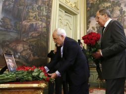 Serguéi Lavrov (i) deposita un ramo de flores ante el retrato de Andréi Kárklov durante un homenaje. AP / M. Shemetov