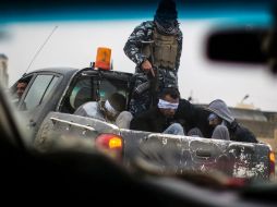 Un miembro de las fuerzas iraquíes traslada a cuatro presuntos miembros del EI tras un combate. AFP / J. Lopez