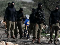 Soldados israelíes detienen brevemente a un niño después de una manifestación contra la expropiación de tierras palestinas. AFP / J. Ashtiyeh