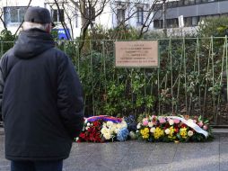 Tres de los periodistas pusieron una corona junto a la placa en la que se recuerda a las 11 personas que fueron asesinadas allí. AFP / E. Feferberg