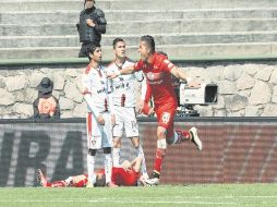 Fernando Uribe celebra el primer gol de los escarlatas, mientras el 'Macue' Robles y Luis Reyes se ven desconcertados por la anotación. MEXSPORT /