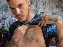 Juan Jose Herrera, hijo de Ismael Enrique Arciniegas, muestra un tatuaje de su padre. AFP / L. Robayo