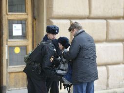 Policías rusos registran la mochila de un hombre a las puertas de una de las estaciones del metro. EFE / Y. Kochetkov