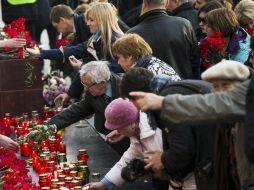 Varias personas dejan flores en el memorial de Leningrado, ante la tumba del Soldado Desconocido, durante la manifestación de hoy. AP / A. Zemlianichenko
