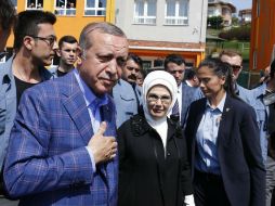 Recep Tayyip Erdogan (i) y su esposa Emin hablan con varios simpatizantes luego de emitir su voto. EFE / S. Suna