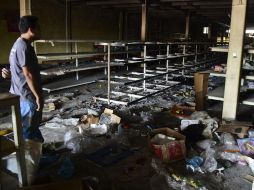 Un hombre mira los daños que dejaron los saqueadores en un supermercado. AFP / R. Schemidt