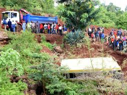 Un grupo de civiles observa el autobús del percance, que transportaba a un grupo de estudiantes de primaria. AFP / F. Rweyemamu