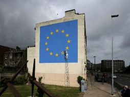 Se trata de un hombre picando con un martillo una de las estrellas de la UE. AFP / D. Leal-Olivas