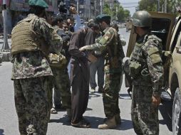 Soldados afganos detienen a un sospechoso de participar en el ataque. EFE / G. Habibi