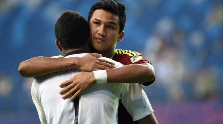 Samuel Sosa abraza a Wuilker Faríñez, quien fue el héroe del partido al atajar dos penaltis. AFP / Y. Lee