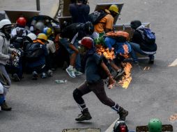Habitualmente, menores de edad con rostros cubiertos se ven en choques con militares y policías. AFP / F. Parra