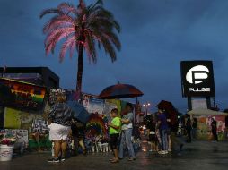 En el exterior del local, numerosas personas se acercaron para recordar a sus amigos caídos y a dejar flores y velas. AFP / J. Raedle