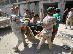 Militares iraquíes trasladan a uno de los heridos en una camilla improvisada al hospital. AFP / A. AL-Rubaye