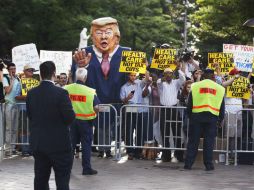 Los manifestantes reunidos afuera del Hotel Internacional Trump portaban pancartas contra las modificaciones al sistema de salud. AP / M. Balce