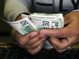 Para este jueves, estiman que el dólar podría oscilar entre 17.94 y 18.02 pesos por dólar. AFP / ARCHIVO