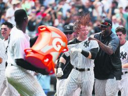 Bautizo. Clint Frazier (centro) fue recibido con bebida isotónica en el plato después de su cuadrangular de tres carreras. AFP / A. Bello