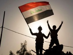Soldados iraquíes ondean la bandera del país mientras celebran la derrota del Estado Islámico. AFP / F. Senna