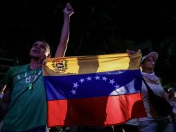 Personas reaccionan al escuchar a los expresidentes latinoamericanos que acompañaron la consulta tras el cierre de las votaciones. EFE / M. Gutiérrez