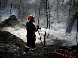 Un bombero trabaja en las labores de extinción de un incendio desatado en Carros, cerca de Niza. EFE / S. Nogier