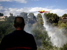 Un helicóptero se suma a las labores de extinción de un incendio en Carros, cerca de Niza. EFE / S. Nogier