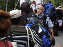 Un agente de la Policía montada advierte a migrantes que podrían ser arrestados por ingresar al país ilegalmente. AP / C. Krupa