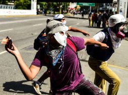 Un manifestante lanza un coctel durante una manifestación en Caracas, hoy sábado 12 de agosto de 2017. AFP / R. Schemidt