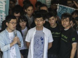 Nathan Law (i), Joshua Wong (c) y Alex Chow (dcha) atienden a la prensa a las puertas del Tribunal Supremo de Hong Kong. EFE / J. Favre